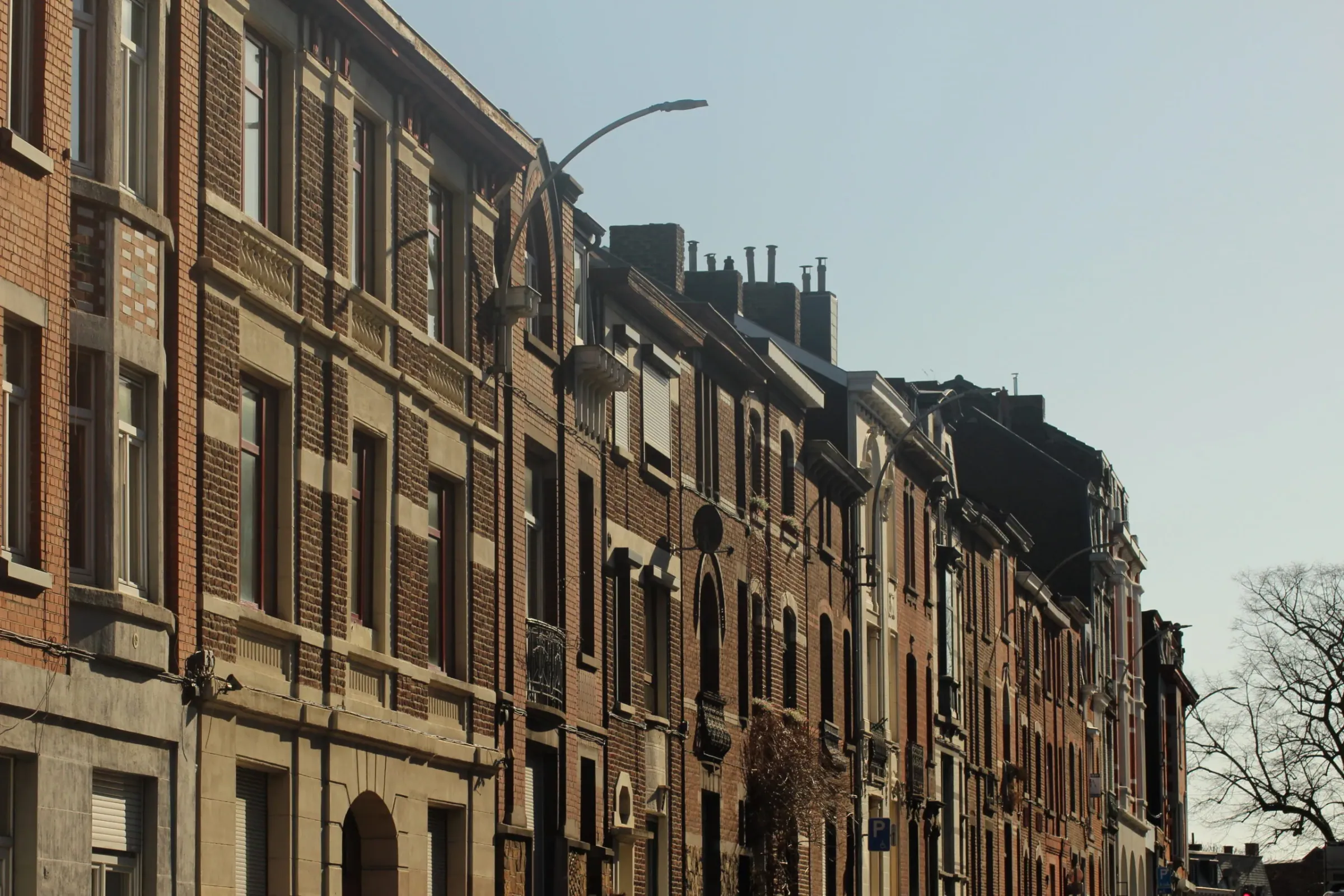 Rangée de maisons de ville belges en briques sur une rue résidentielle