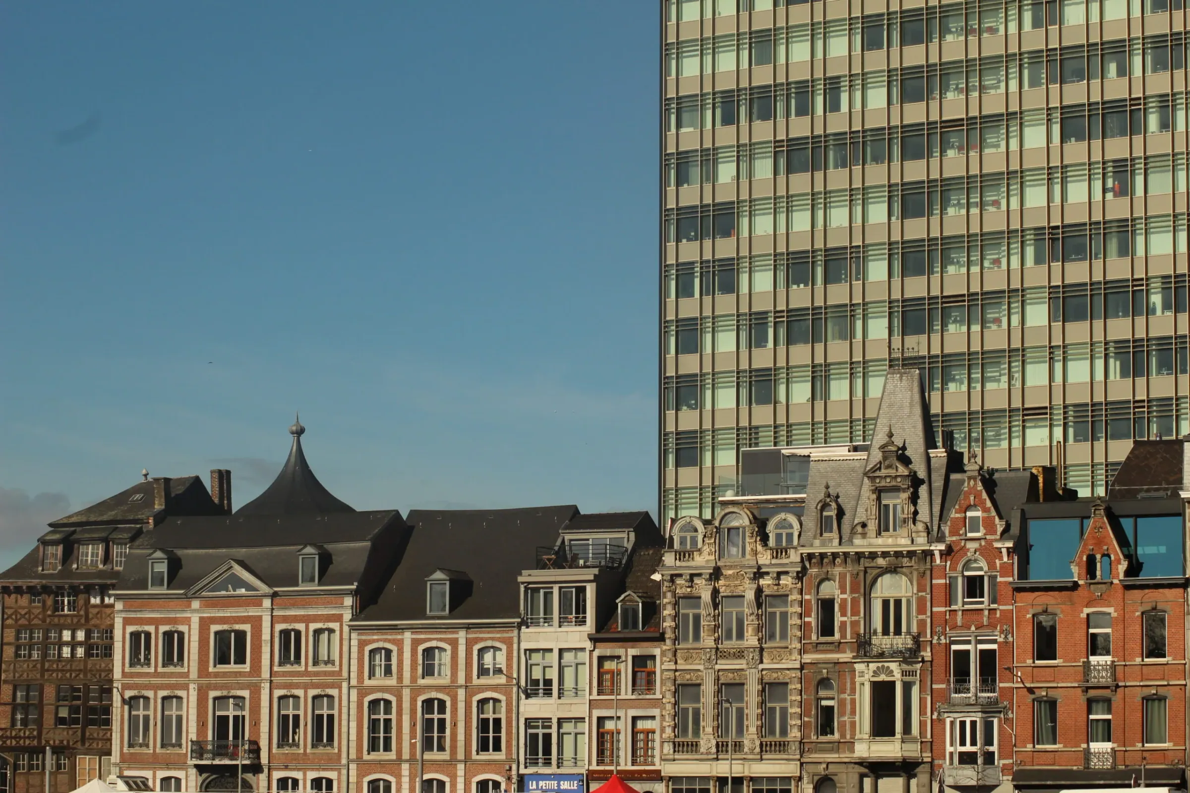 Façades contrastées de maisons urbaines belges, briques et enduits clairs